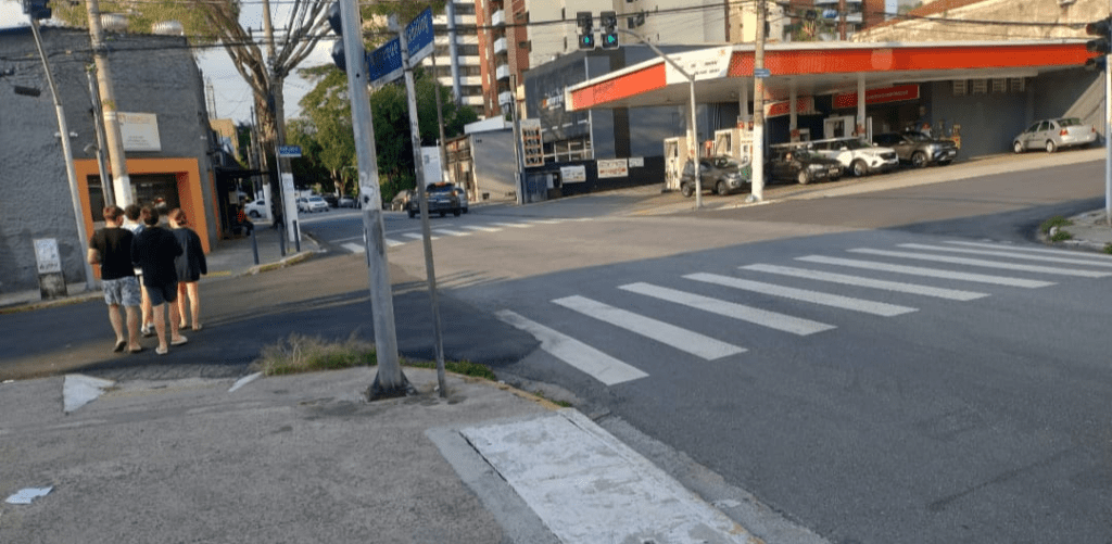 Pedestres pedem semáforo para travessia segura na Rua Schilling